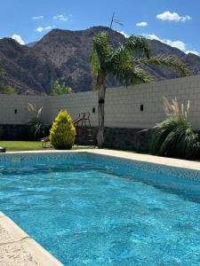 uma piscina azul com uma montanha ao fundo em Mi Sanagasta Querida em La Rioja