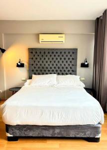 1 dormitorio con 1 cama blanca grande y cabecero en Departamento en San Isidro Ap802 en Lima