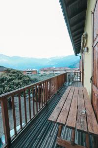 a wooden bench on a balcony with mountains in the background at Agritur il Torchio in Arco