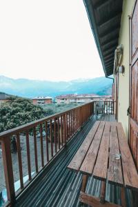 d'un banc en bois sur un balcon avec des montagnes en arrière-plan. dans l'établissement Agritur il Torchio, à Arco