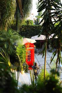 een rode telefooncel in een tuin met bomen bij Hotel Grand Vista Cuernavaca in Cuernavaca