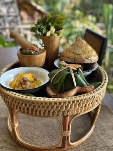a wicker table with a plate of food on it at Greenheart garden View Camp phuket in Kata Beach