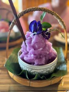 a bowl of purple sorbet with a blue flower on it at Greenheart garden View Camp phuket in Kata Beach