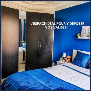 a bedroom with a bed and a blue wall at Perle Haussmannienne 1900 - Cosy - Centre ville in La Garenne-Colombes