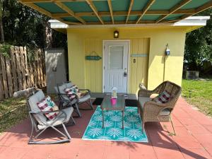 un patio con sedie e un tavolo su una casa di 3 Bedroom House Option or 1 Bedroom Cottage Option or 3 Bedroom House plus 1 Bedroom Cottage Option that Sleeps 12 For Large Groups! FENCED BACKYARD PRIVATE PATIO AREAS! GRILL FIREPIT! PLENTY PARKING! and Boat Parking upon request a Lake Worth