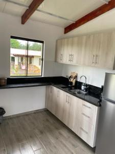een keuken met een wastafel en een koelkast bij Residencia Piri in Piribebuy