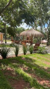 einen Picknickbereich mit Bänken und einem Strohschirm in der Unterkunft Residencia Piri in Piribebuy