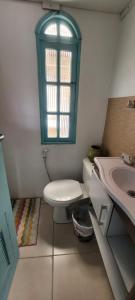 uma casa de banho com um WC e um lavatório com uma janela em Casa 3 quartos 2 banheiros patio gramado fechado com piscina em Guarapari