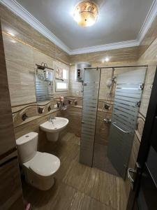 a bathroom with a toilet and a sink and a shower at شقة فندقية على النيل مباشر بالمعادى ٣ غرف ٣ حمام in Cairo