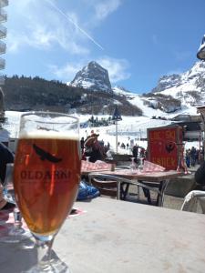 un vaso de cerveza sentado en una mesa frente a una pista de esquí en Appartement rue de la cascade 64440 Eaux-Bonnes, en Eaux-Bonnes