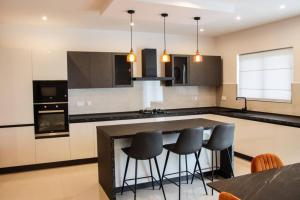 a kitchen with black and white counters and stools at Amazing 2BED Ghadira! by Homely in Mellieħa