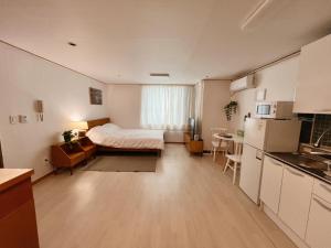 a small room with a bed and a kitchen at Easy access to Metro in Seoul