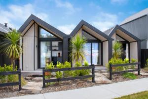 a house with a black roof at Matakana Luxury Escapes in Matakana