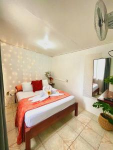 um quarto com uma cama com uma flor em Tico Bed & Breakfast La Fortuna em La Fortuna