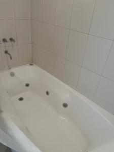 d'une baignoire blanche avec une douche en carrelage blanc. dans l'établissement Catedral Ski & Summer, à San Carlos de Bariloche 10 autres photos