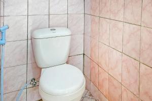 aseo blanco en un baño con azulejos rosas en Cigadog Residence Mitra Reddoorz, en Ciwidey