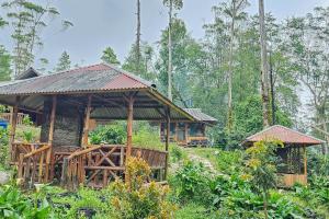 un edificio en medio de un bosque en Cigadog Residence Mitra Reddoorz, en Ciwidey