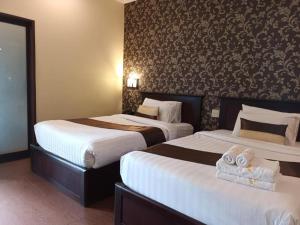 een hotelkamer met 2 bedden en handdoeken erop bij Seasons Riverside Hotel in Vientiane