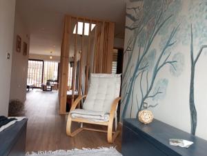 uma sala de estar com uma cadeira branca e uma parede em Casa Boqui Hostal em Panguipulli