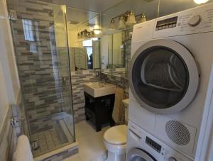 a washer and dryer in a bathroom with a toilet at Room at the Heart of East Village in New York