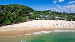 an aerial view of a beach with people on it at Netanya Noosa Beachfront Resort in Noosa Heads