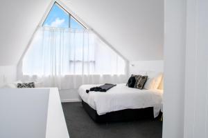 a bedroom with a bed and a large window at Matakana Luxury Escapes in Matakana