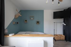 Schlafzimmer mit einem Bett mit blauer Wand in der Unterkunft Pretty ski nest in the city center in Gérardmer
