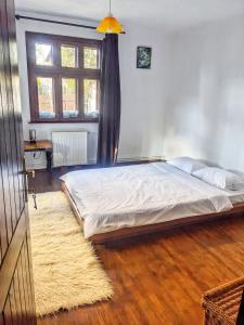 a bedroom with a bed and a window and a rug at Thee&Thou Cottage in Breaza