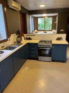 a kitchen with blue cabinets and a stove top oven at Zanzibar in Dar! A newly renovated 3br villa in Dar es Salaam