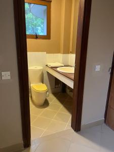 a bathroom with a toilet and a sink at Zanzibar in Dar! A newly renovated 3br villa in Dar es Salaam