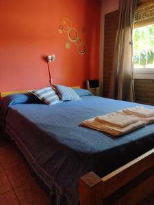 a bedroom with a blue bed with an orange wall at Cabañas AK Tu Lugar in Potrero de los Funes +72 photos