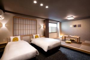 1 dormitorio con 2 camas y ventana en Rinn Kyoto Station West, en Kioto
