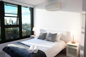 a bedroom with a bed with two white towels on it at Pars apartments - Melbourne Quarter- unique View of city and Yarra in Melbourne