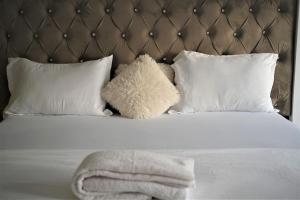 a stuffed teddy bear sitting on a bed with pillows at Apartament Mangalia in Mangalia