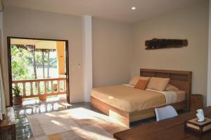 a bedroom with a bed and a balcony at Wichouda Cottage in Chiang Dao