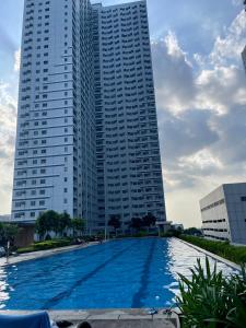 duży basen przed dwoma wysokimi budynkami w obiekcie The Grass Residences w mieście Manila