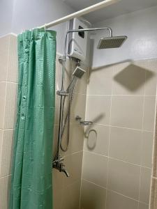 łazienka z prysznicem z zieloną zasłoną prysznicową w obiekcie The Grass Residences w mieście Manila