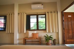 une chambre avec une fenêtre, une chaise et une plante dans l'établissement Wichouda Cottage, à Chiang Dao