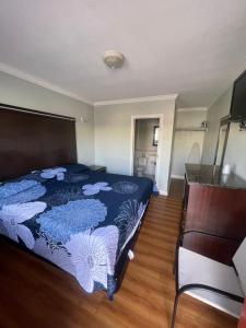 a bedroom with a bed with a blue comforter at La Cienega Inn Motel in Los Angeles