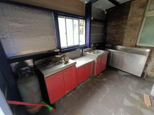 a kitchen with red cabinets and a sink and a window at 馬祖津沙背包客棧-Jinsha backpacker inn in Nangan
