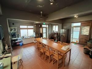 a kitchen and dining room with a wooden table and chairs at 馬祖津沙背包客棧-Jinsha backpacker inn in Nangan