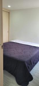 een slaapkamer met een bed met paarse lakens bij Disfruta de Comodidad y Tranquilidad in Bogota