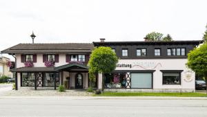 un bâtiment rose et blanc sur le côté d'une rue dans l'établissement Gästehaus Sattlerhof, à Bernau am Chiemsee