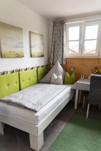 a bedroom with a bed and a table and windows at Gästehaus Sattlerhof in Bernau am Chiemsee