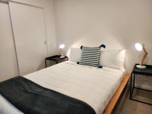 ウェリントンにあるU Suites on Victoriaのベッドルーム(白い大型ベッド、ランプ2つ付)