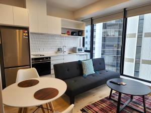 a living room with a couch and tables and a kitchen at U Suites on Victoria in Wellington