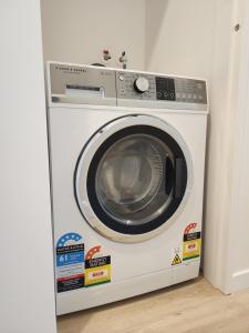 una lavadora blanca en una esquina de una habitación en U Suites on Victoria, en Wellington