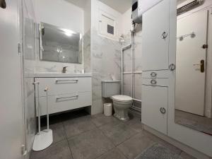 een witte badkamer met een toilet en een wastafel bij Appartement Saint-Jean-de-Luz, 1 pièce, 4 personnes - FR-1-239-858 in Saint-Jean-de-Luz