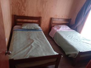two beds in a small room at Cabañas maule in Coronel