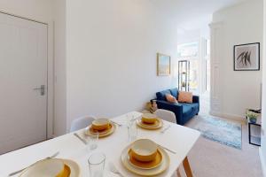 una sala de estar con una mesa blanca con platos. en Stylish and Modern 3 Bed Home - 5*, en South Shields